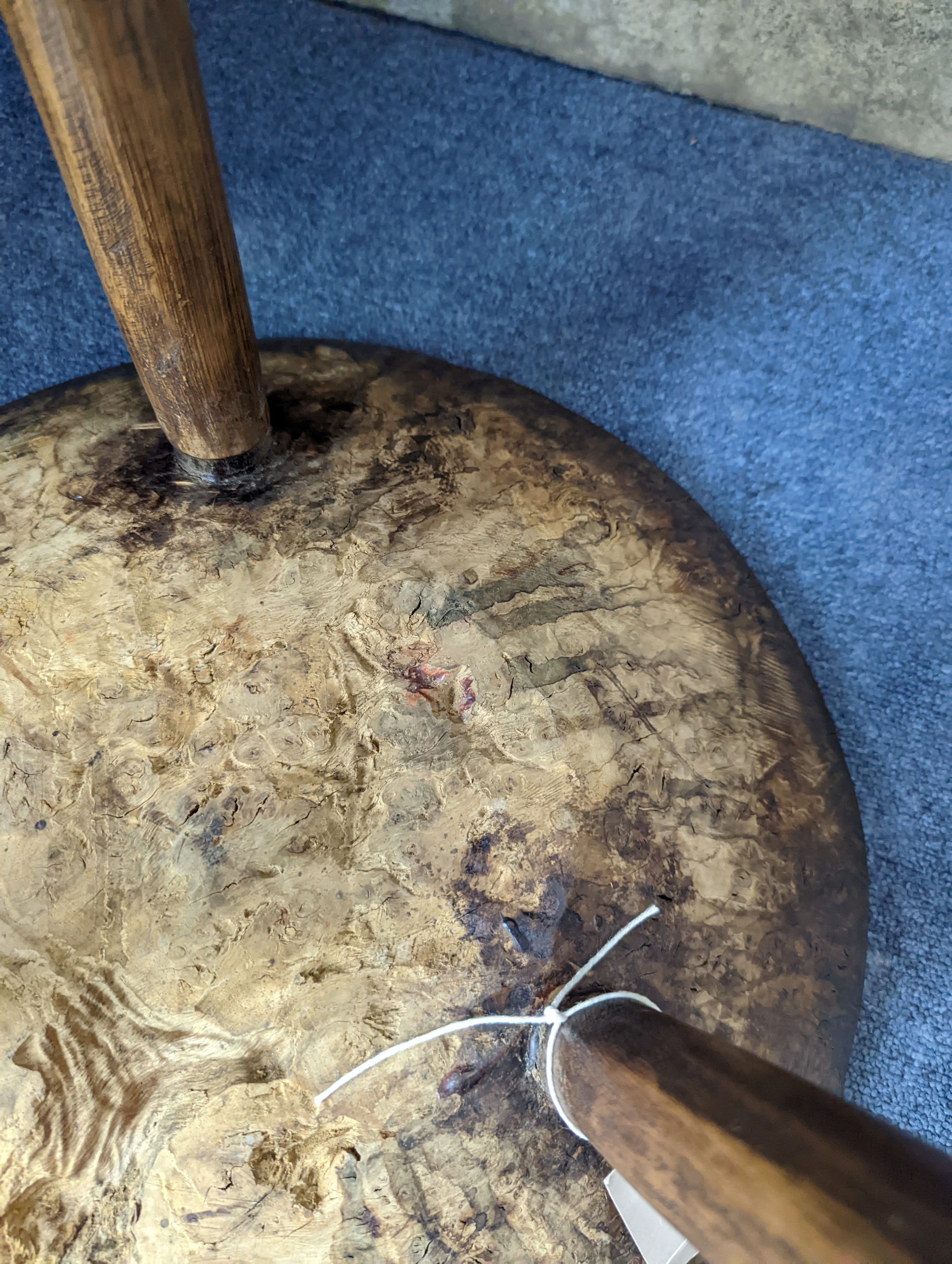 A circular burr elm and ash primitive cricket table with T shaped stretcher, diameter 44cm, height 61cm